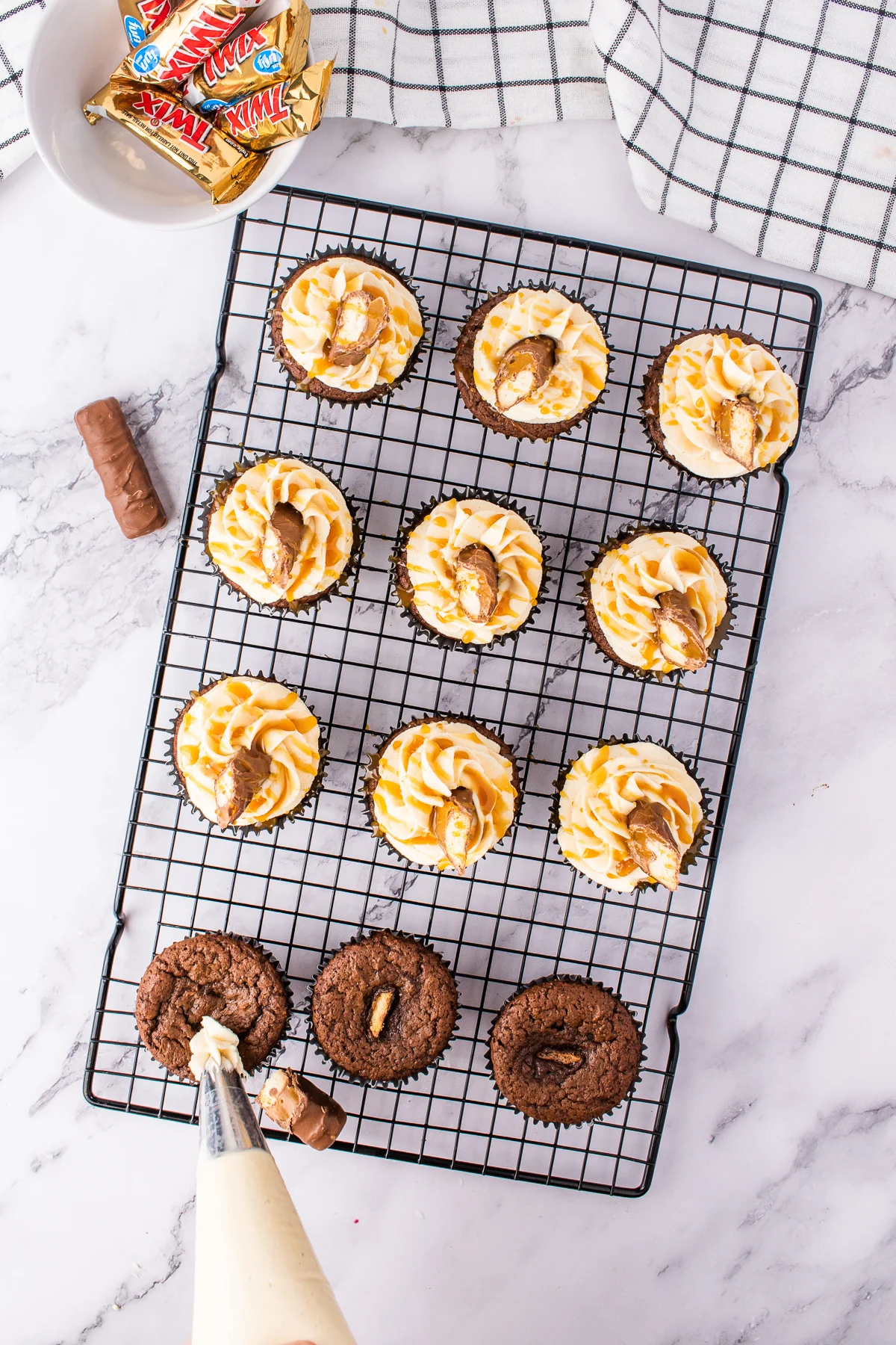 overhead shot of frosting twix bar cupcakes