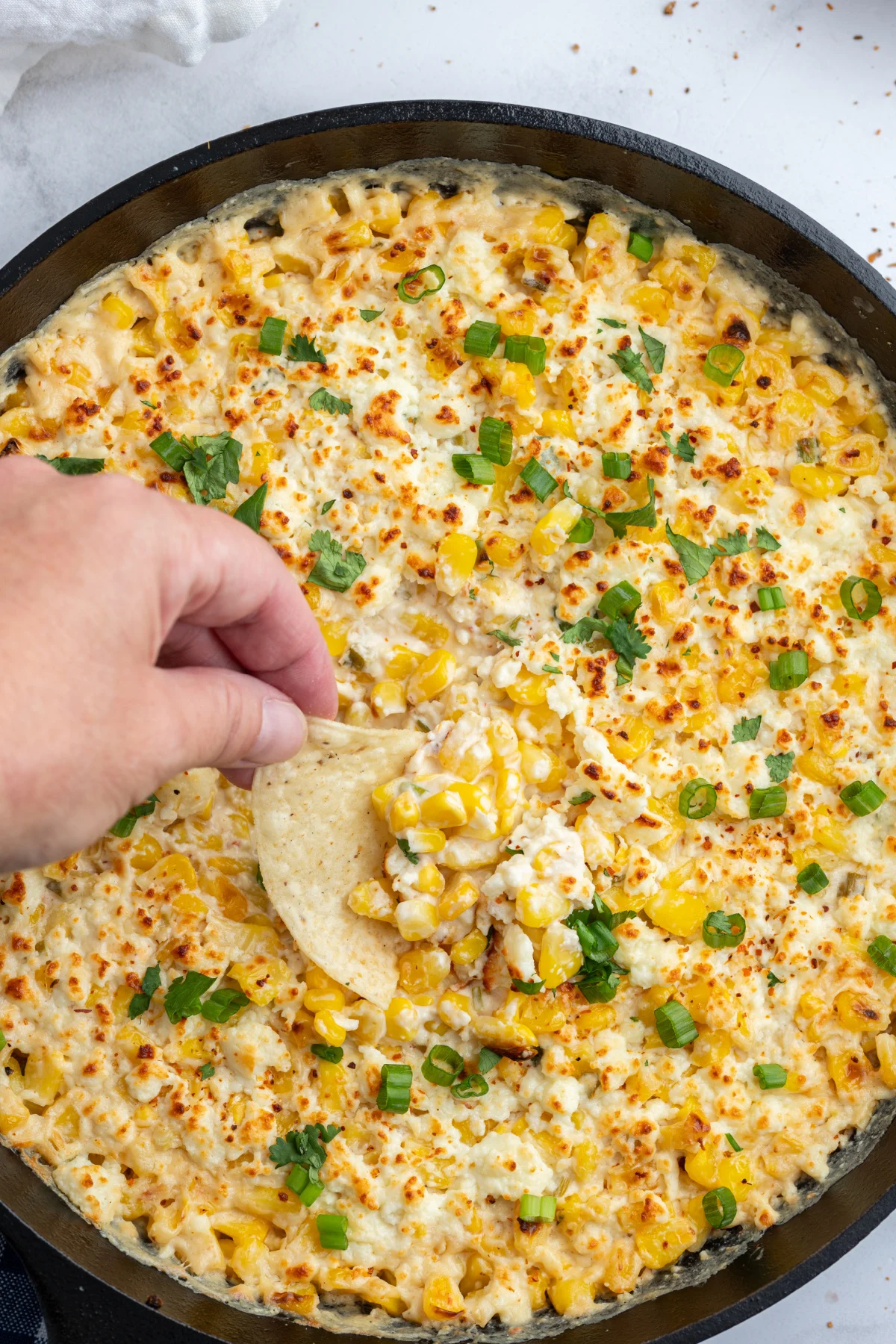 dipping chip in baked elote dip