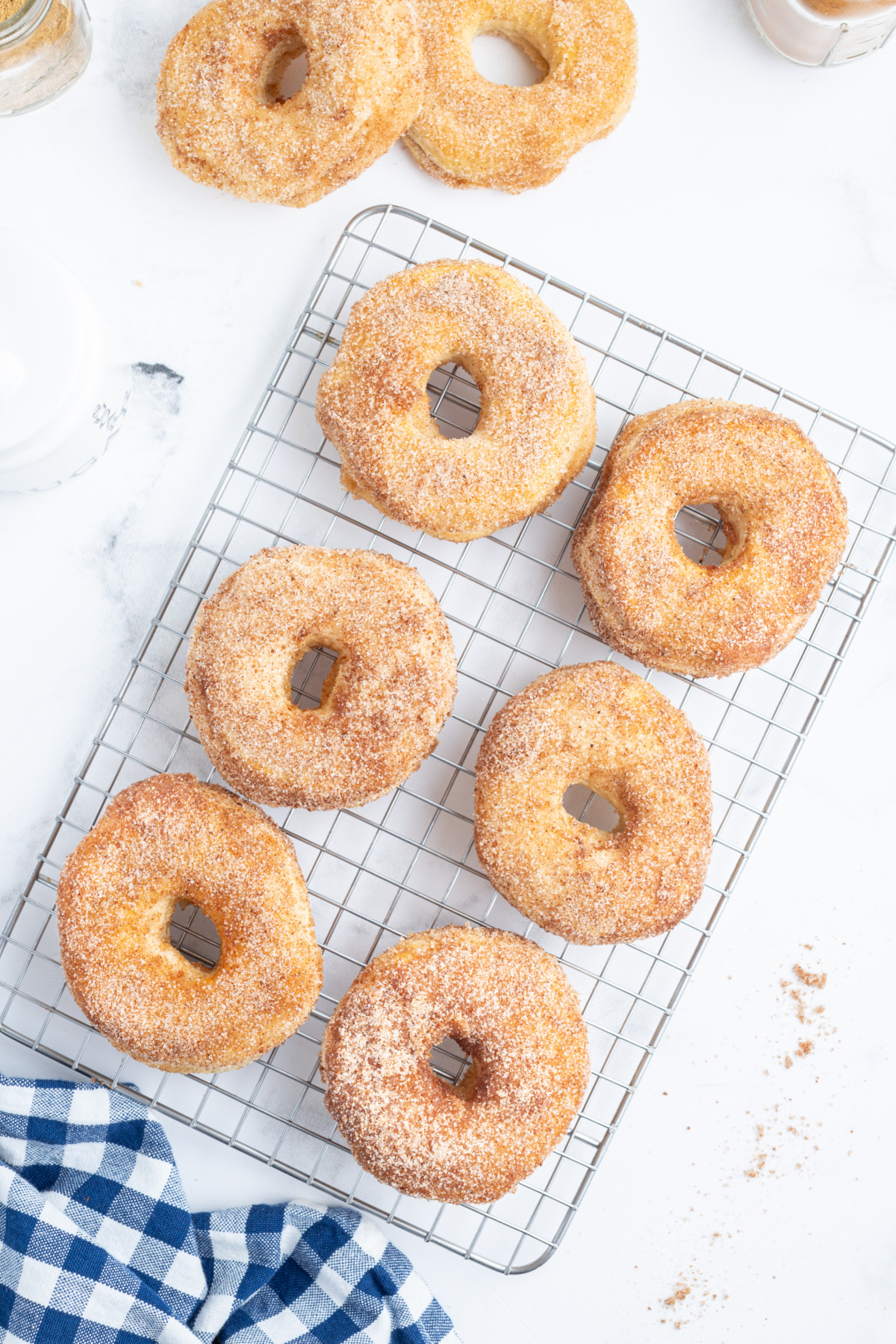 several cinnamon sugar donuts on cooling rack