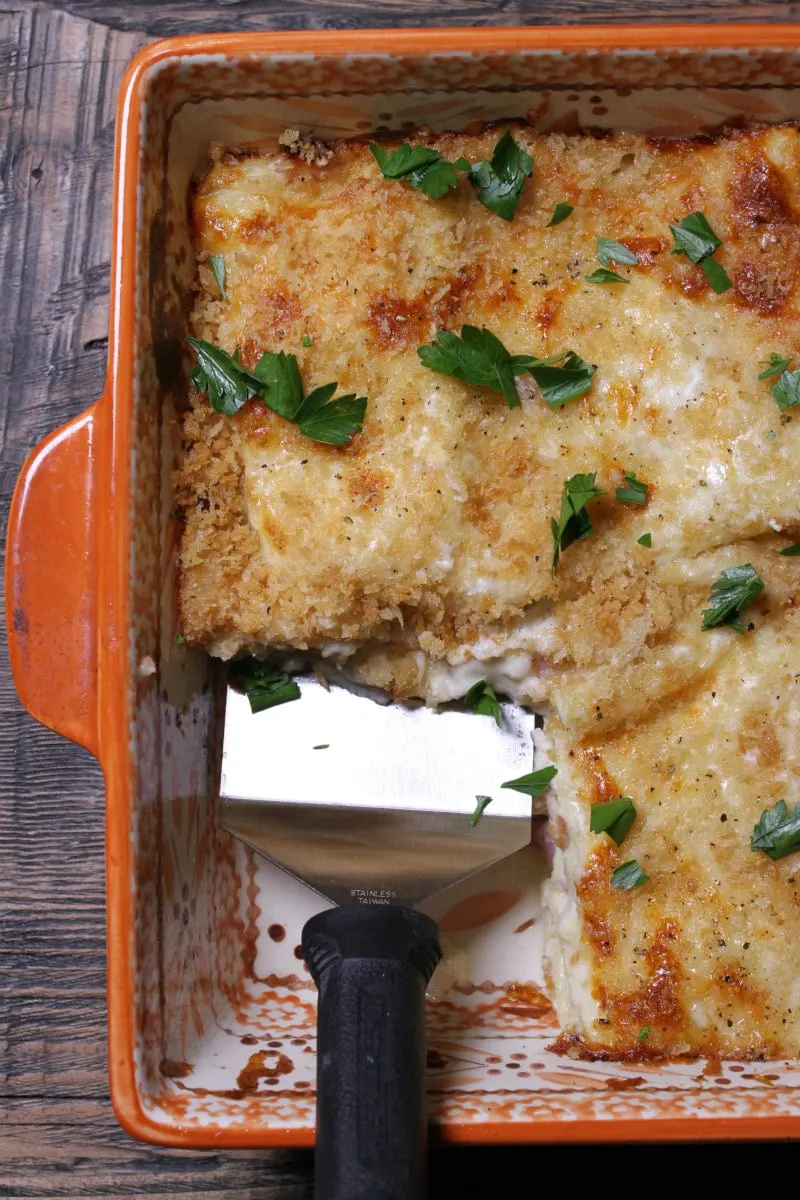 Chicken Cordon Bleu Lasagna with spatula taking out slice