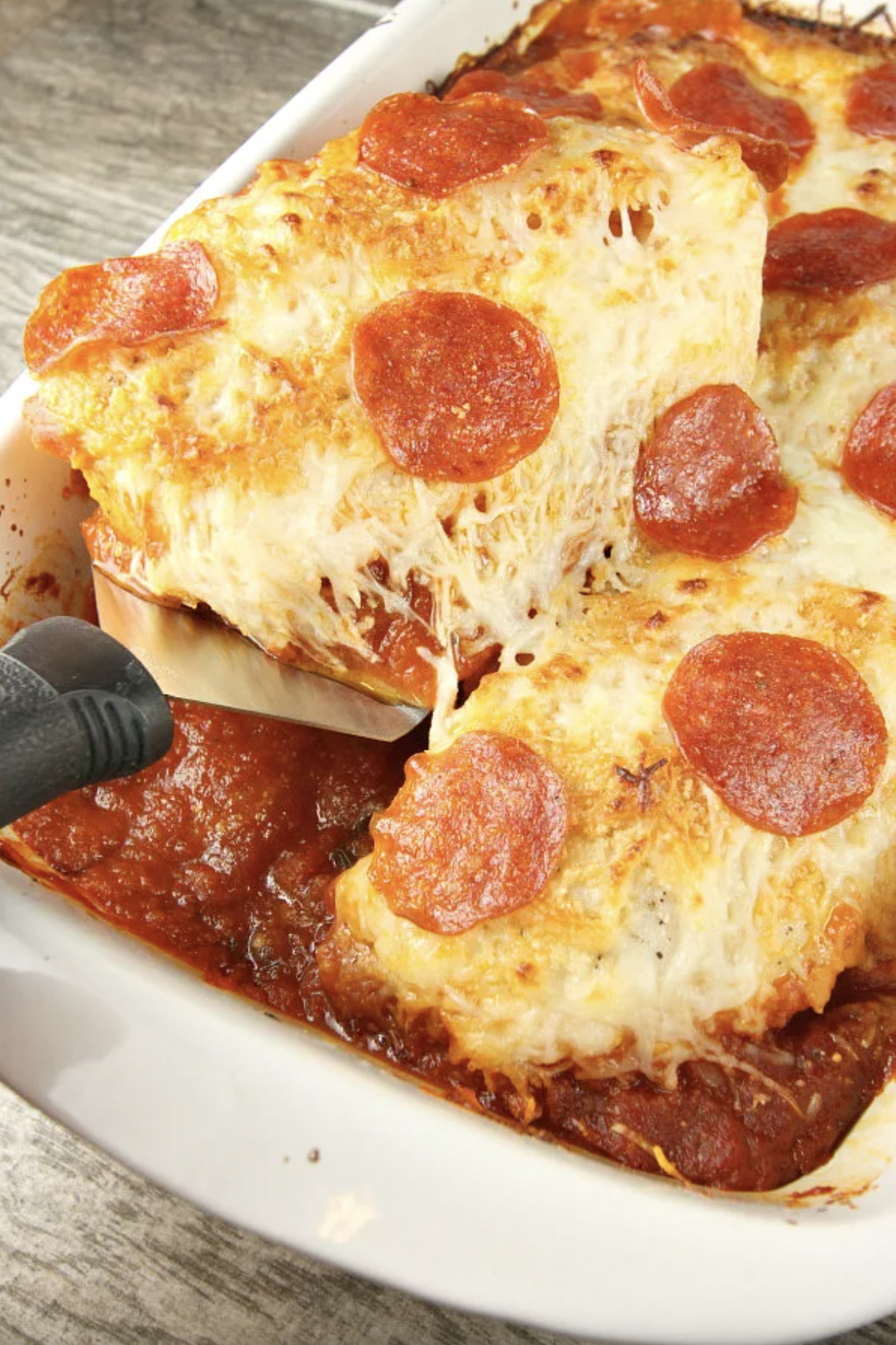 chicken pizzaiola in a baking dish with spatula