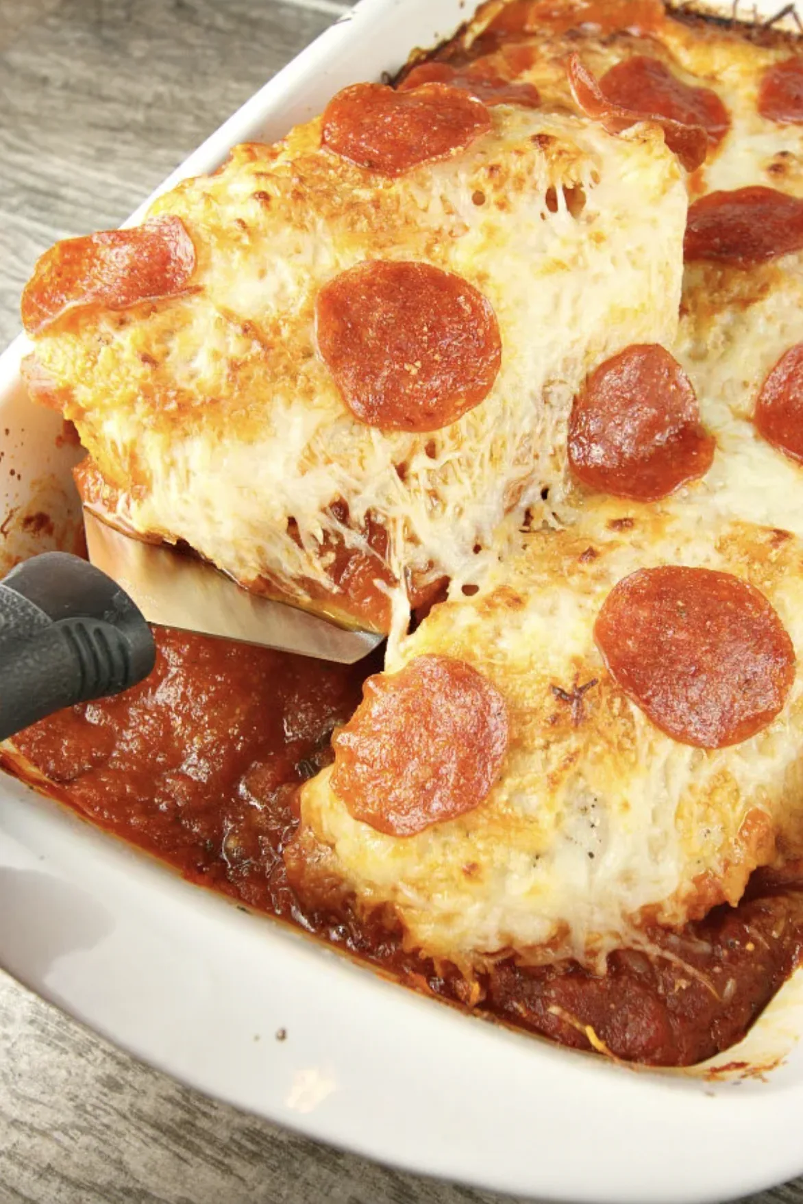 25 Easy Family Friendly Chicken Dinner Recipes from RecipeBoy.com chicken pizzaiola in a baking dish with spatula