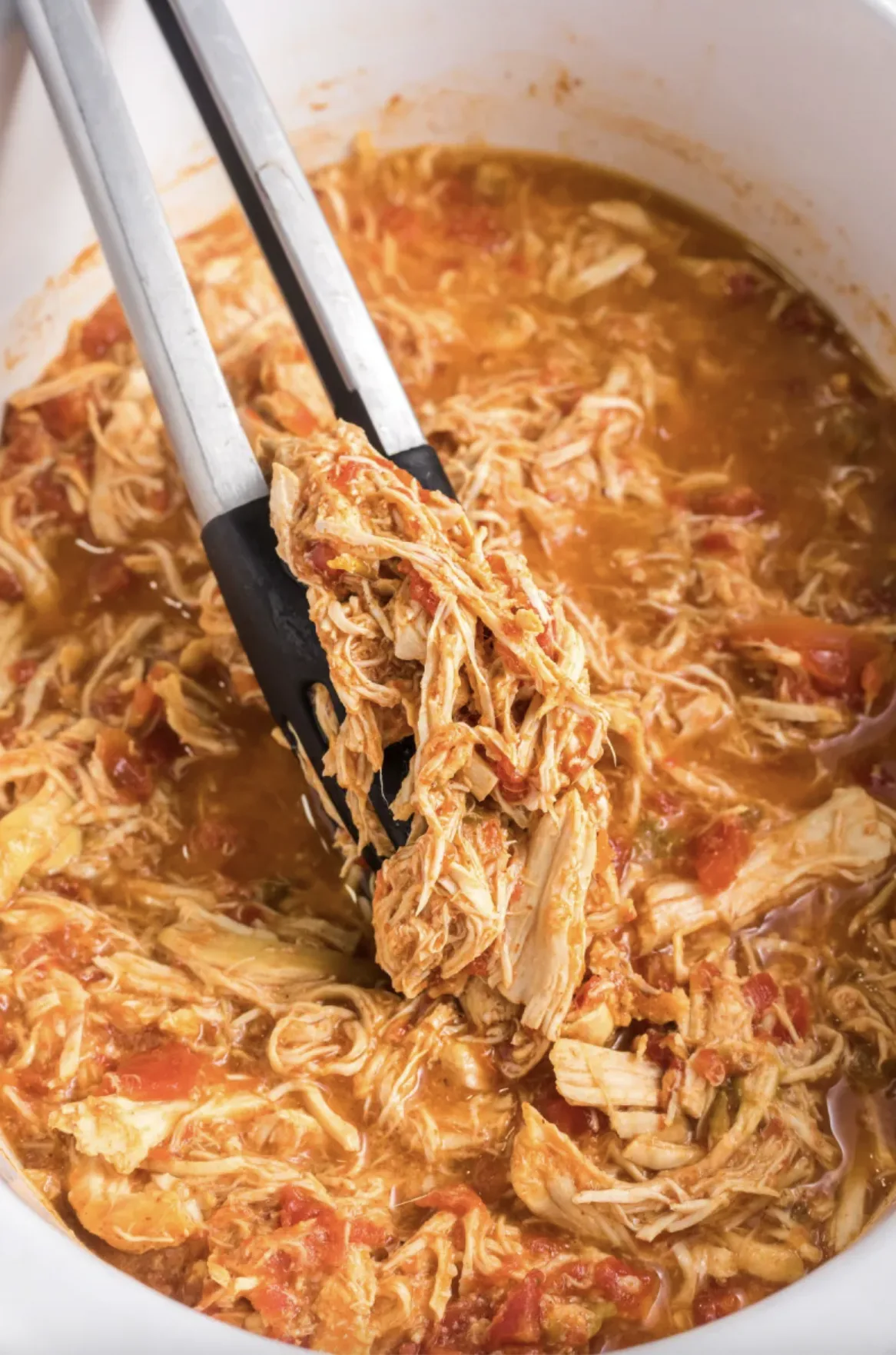 slow cooker mexican chicken in slow cooker with tongs