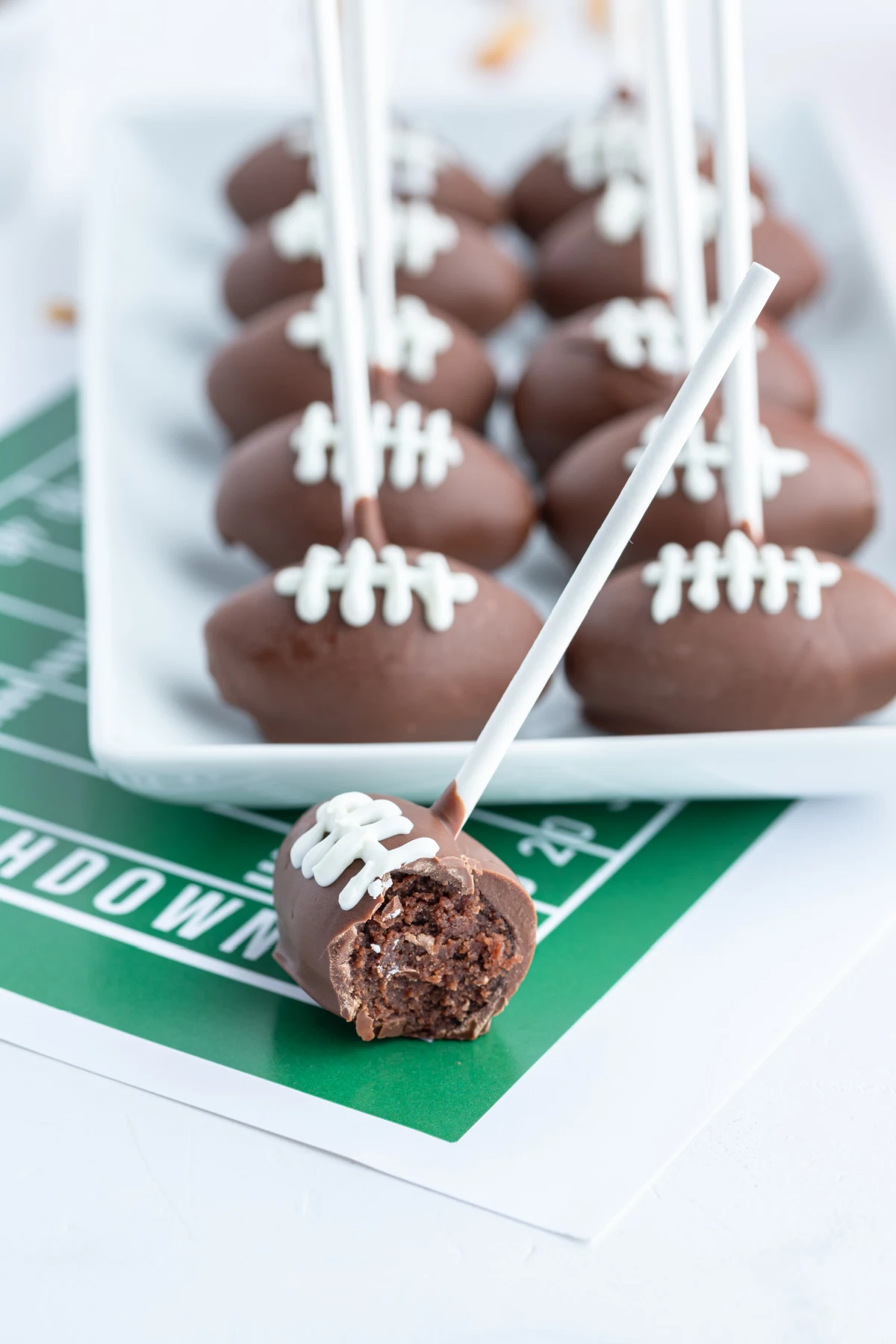 football cake pops on platter with one bitten open