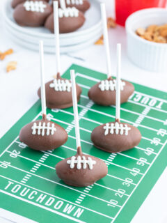 football cake pops displayed on green graphic football field
