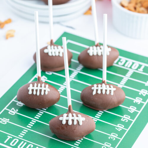 football cake pops displayed on green graphic football field