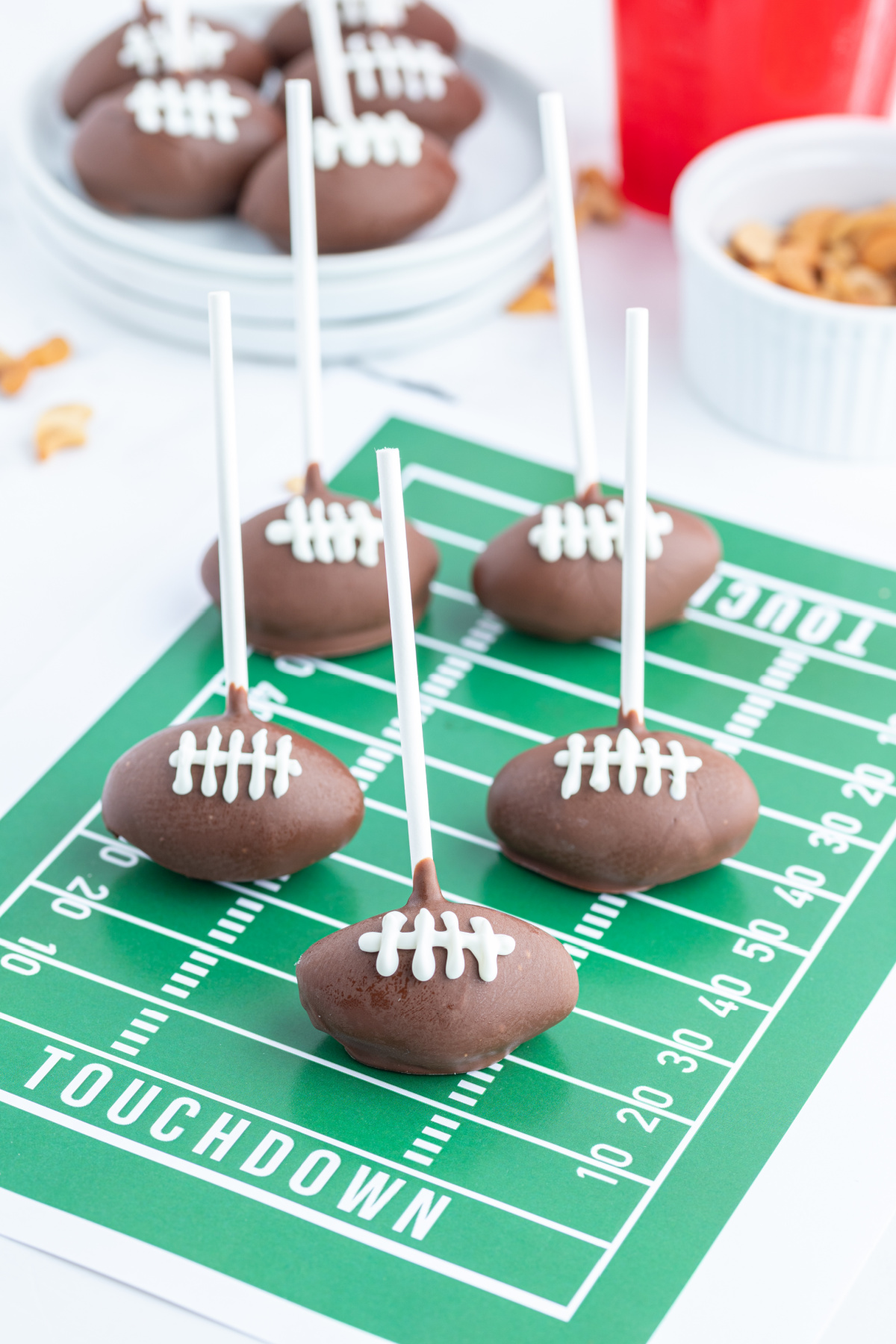 football cake pops displayed on green graphic football field