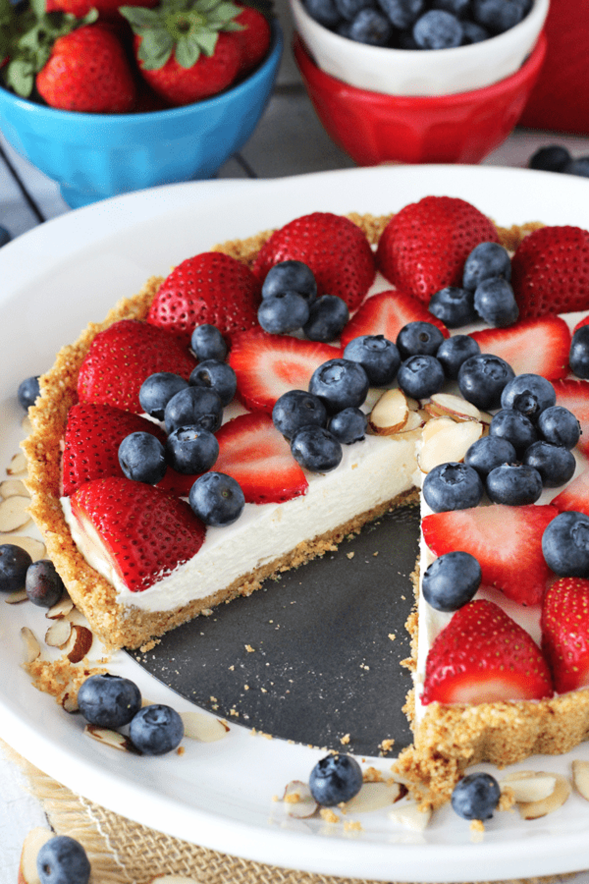 no bake berry almond tart on plate with slice taken out