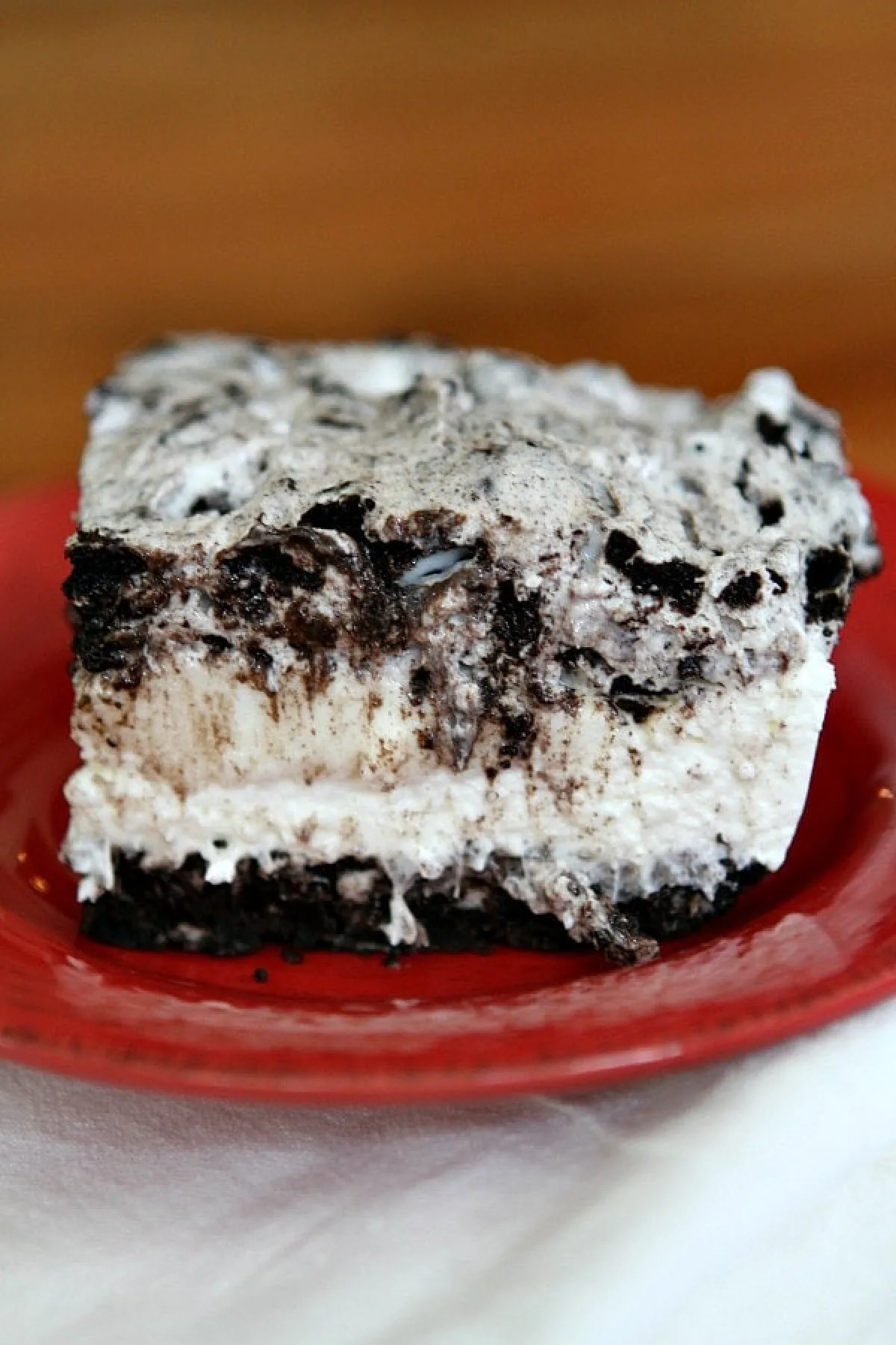 slice of no bake oreo cheesecake bars on red plate