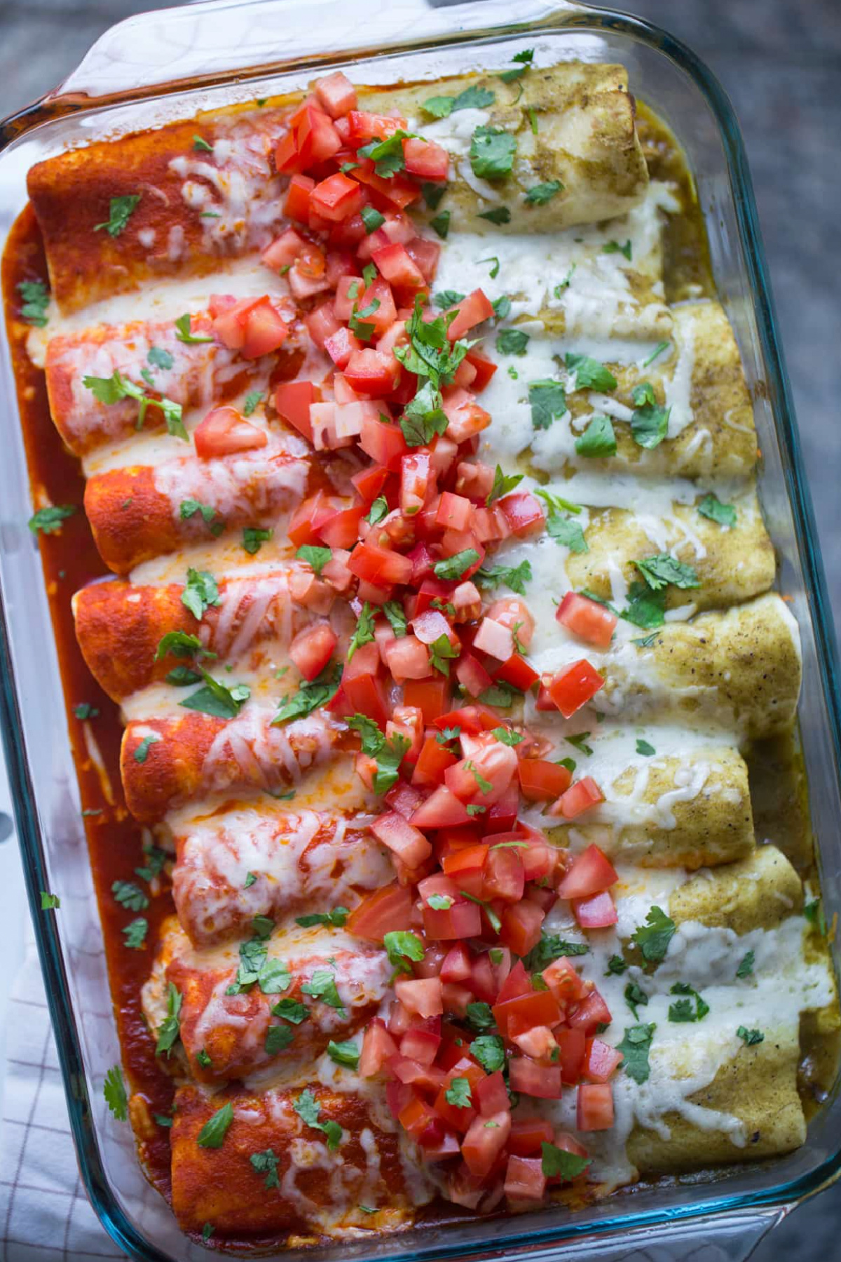 red and green enchiladas in baking dish