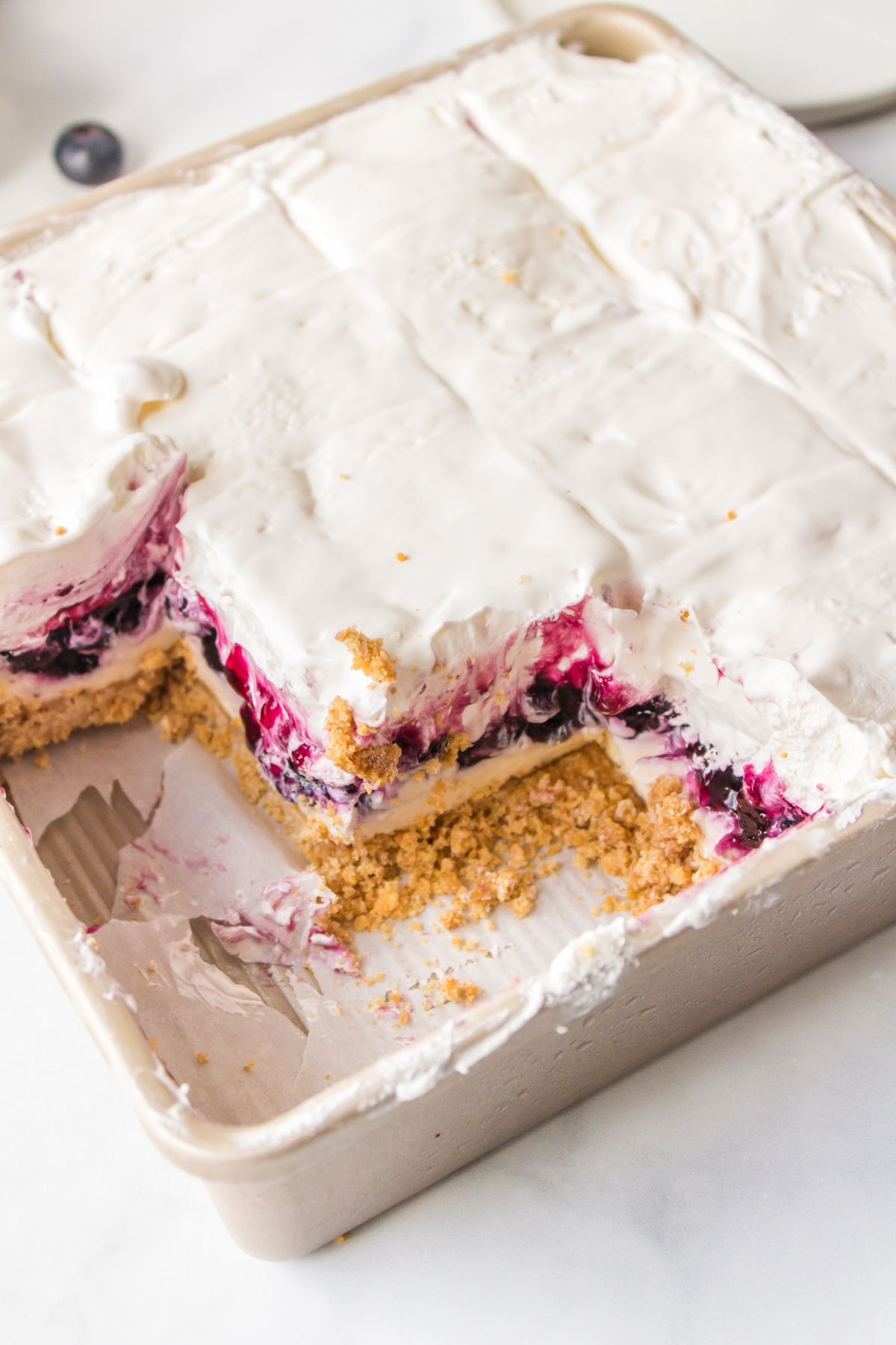 pan of blueberry cream cheese squares in pan with some taken out
