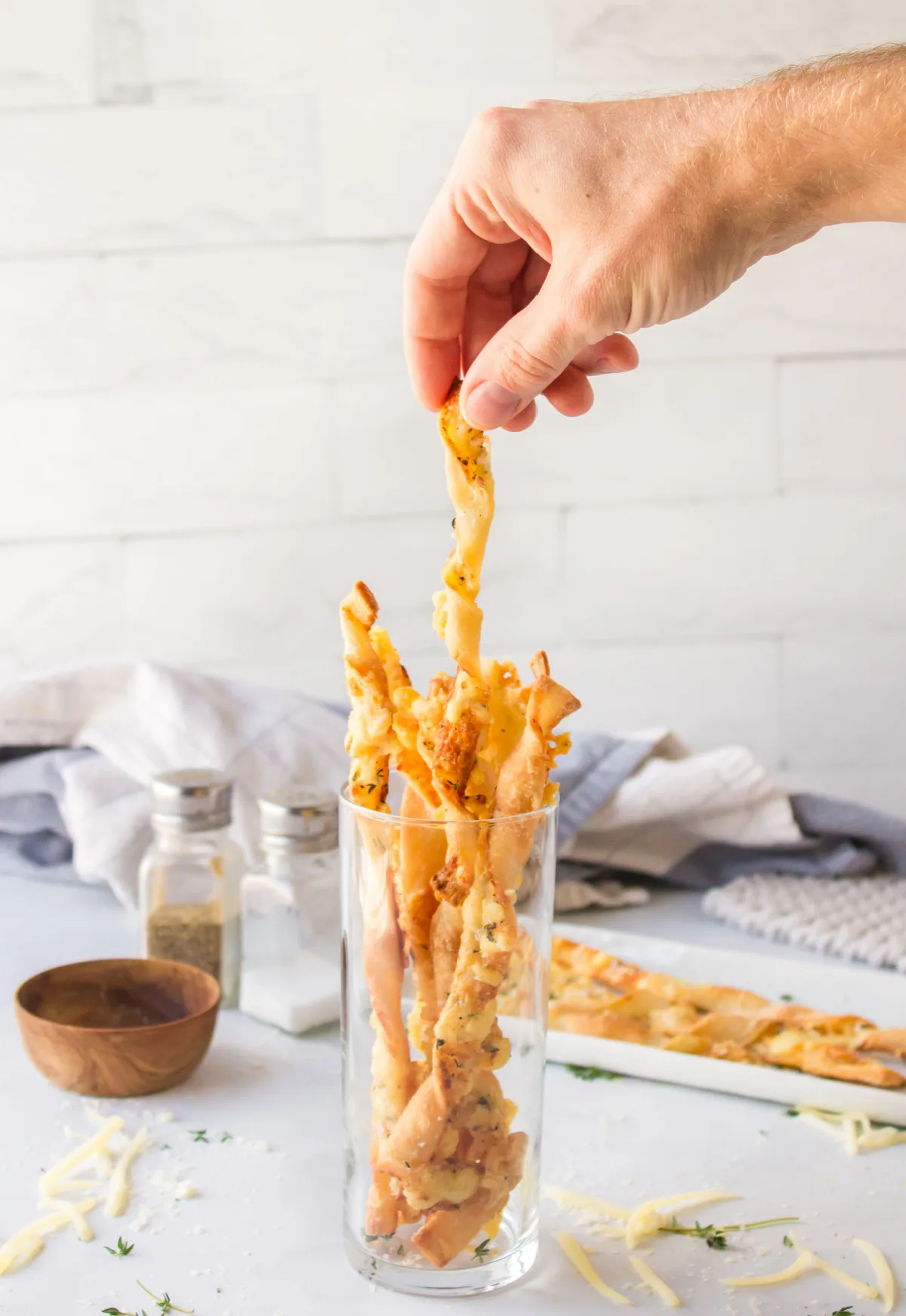 Cheese Straws recipe from RecipeBoy.com hand picking cheese straw from glass