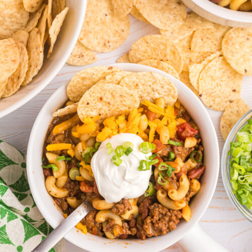 beef chili mac in bowl with sour cream