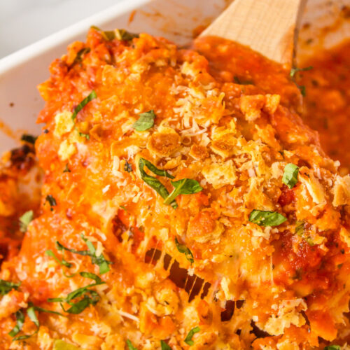 spoon in pan of baked parmesan chicken