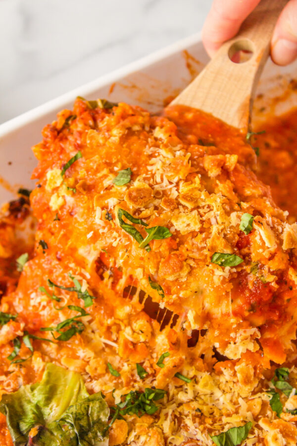 spoon in pan of baked parmesan chicken