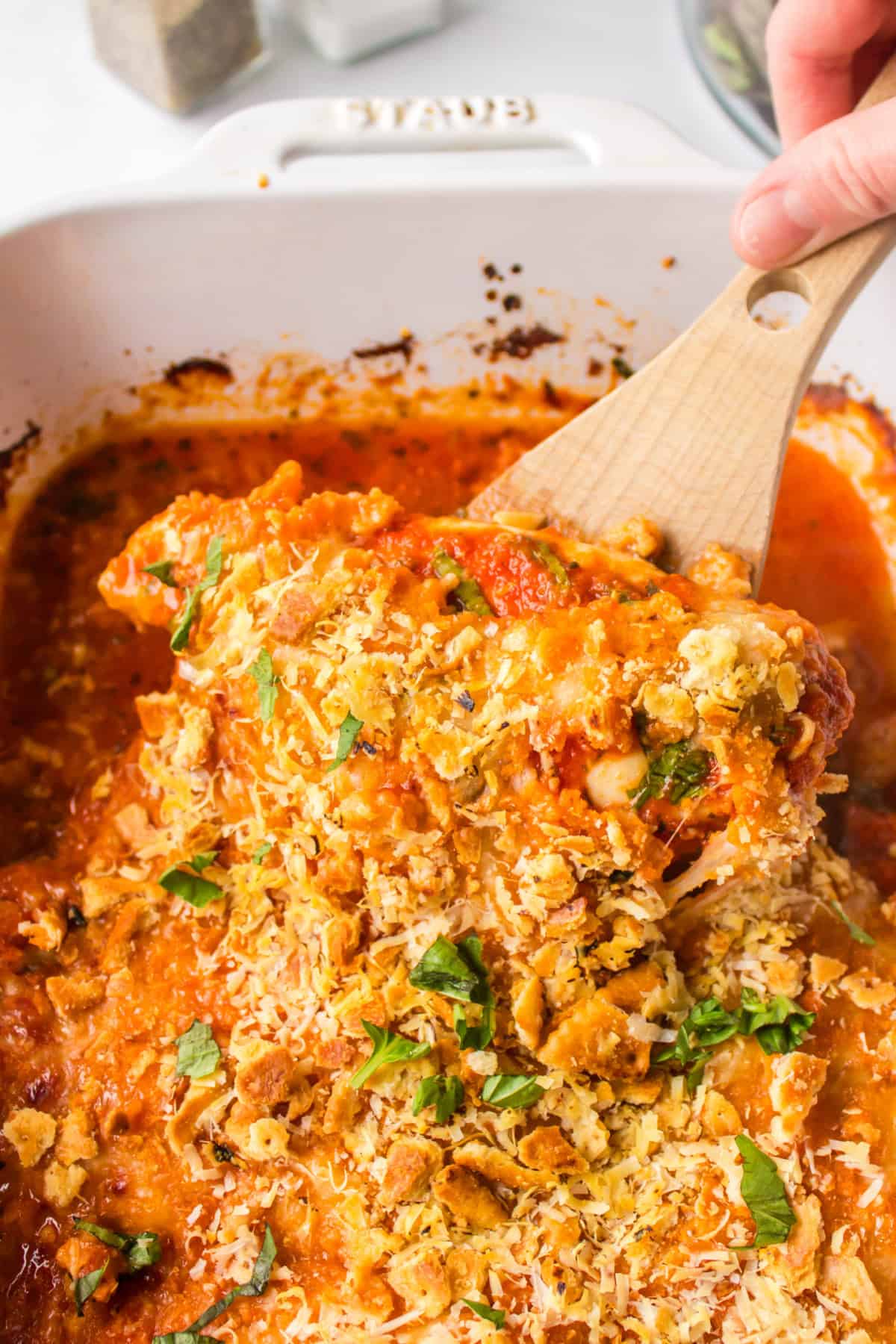 Make Chicken Parm the easy way! Baked Parmesan Chicken is juicy, cheesy, and topped with a buttery Ritz cracker crust. It’s loaded with flavor from garlic, Parmesan, and marinara — total family fave. Close-up of cheesy baked chicken with marinara sauce and basil.