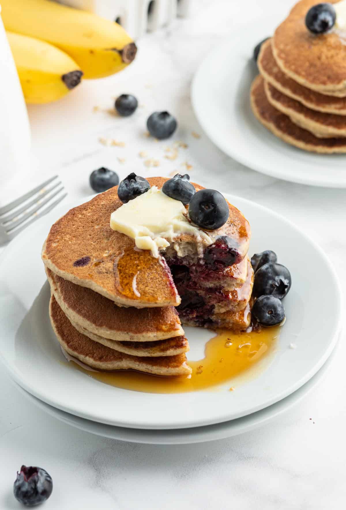 stack of oatmeal blender pancakes with wedge bite taken out of them.