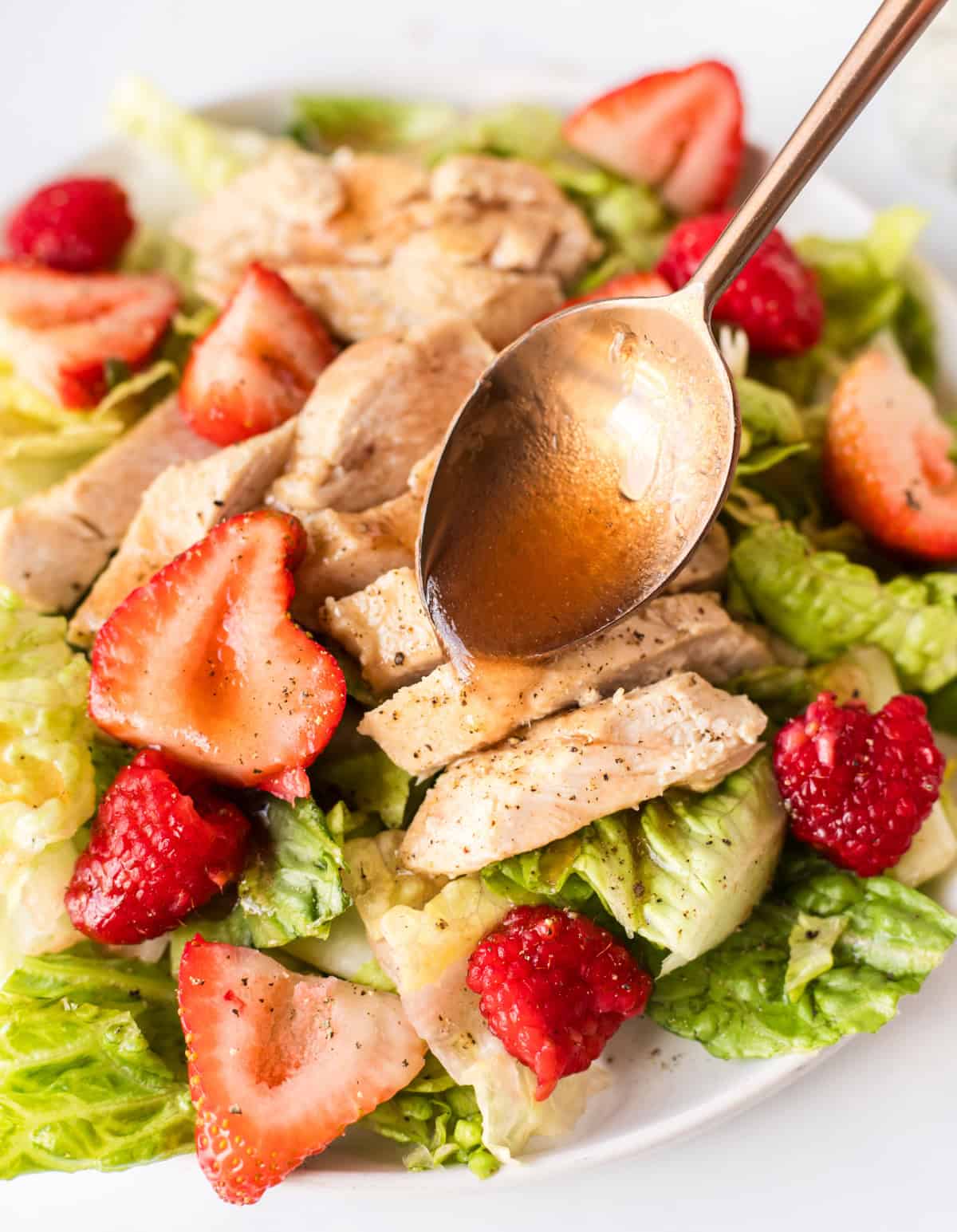Berry Chicken Salad recipe from RecipeBoy.com spooning dressing onto berry chicken salad