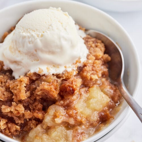 serving of apple betty in dish with ice cream