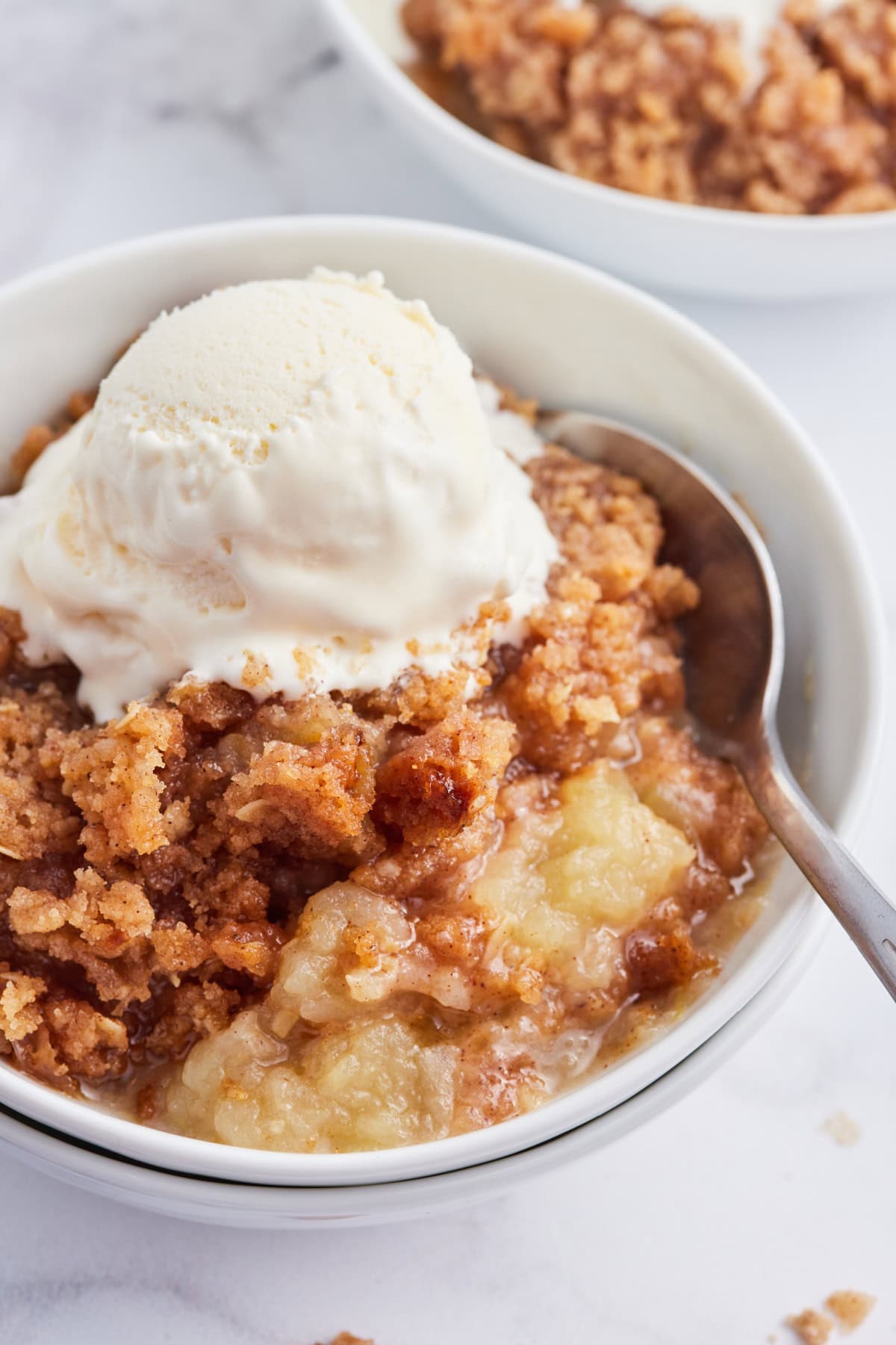 serving of apple betty in dish with ice cream