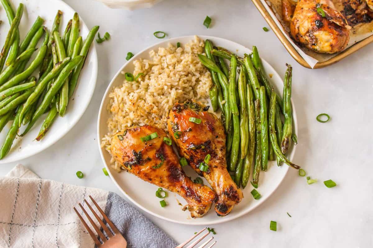 This Honey Chicken Drumsticks recipe is an easy, family friendly dinner recipe, and you will only need 5 ingredients to make it. plate of honey chicken drumsticks with rice and green beans