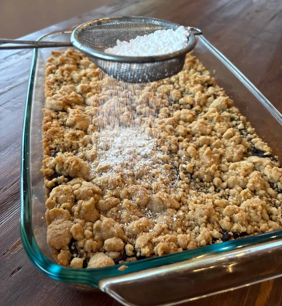 Apple Butter Shortbread Bars are a totally decadent dessert with two layers of buttery shortbread and apple butter sandwiched in between. Recipe from RecipeBoy.com dusting powdered sugar onto apple butter shortbread bars