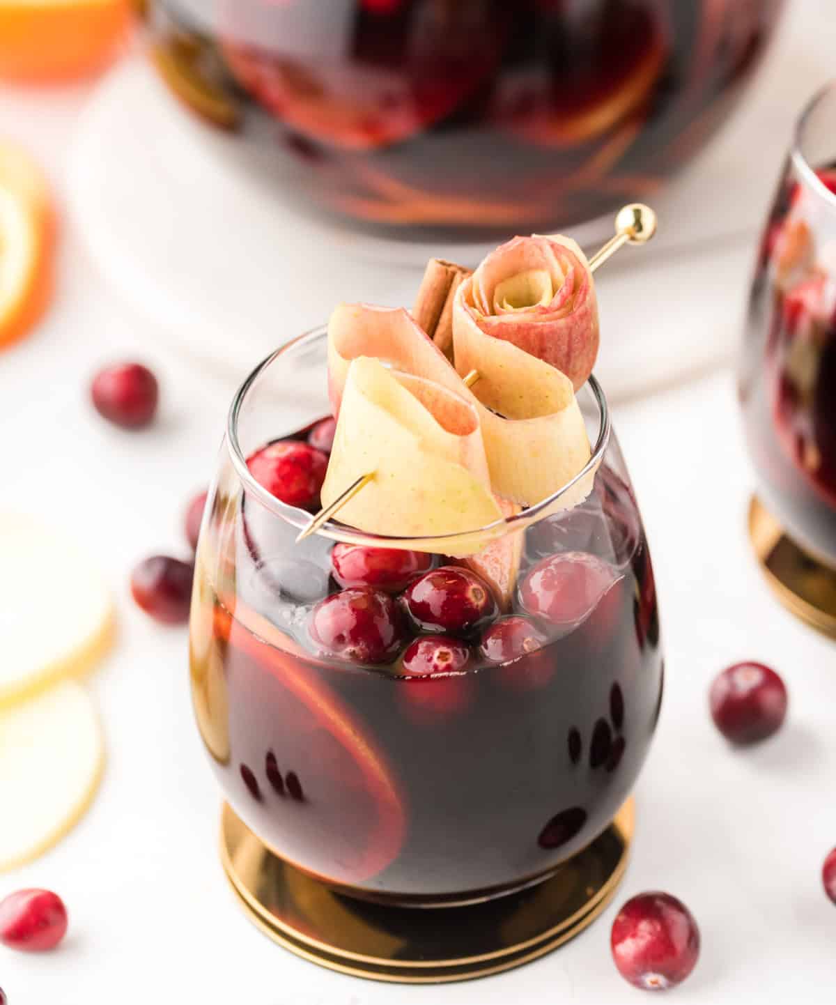glass of apple cranberry sangria with apple garnish