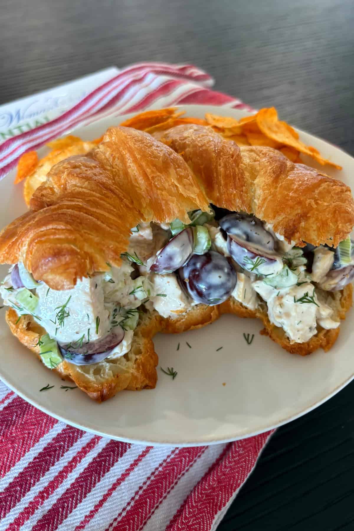 This creamy chicken salad from Pioneer Woman’s The Essential Recipes cookbook is filled with grapes, dill, and lemony dressing. A fresh, make-ahead lunch idea! chicken salad sandwich on a plate