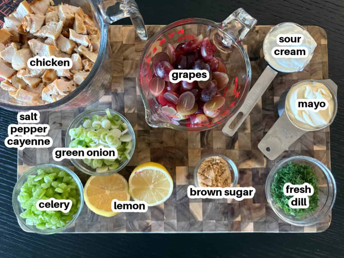This creamy chicken salad from Pioneer Woman’s The Essential Recipes cookbook is filled with grapes, dill, and lemony dressing. A fresh, make-ahead lunch idea! ingredients displayed for making chicken salad