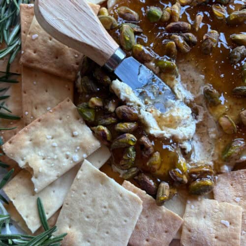 spreader on top of boursin cheese dip with crackers