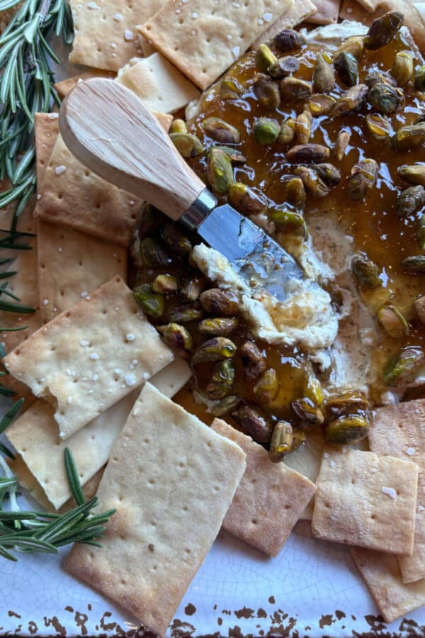 spreader on top of boursin cheese dip with crackers