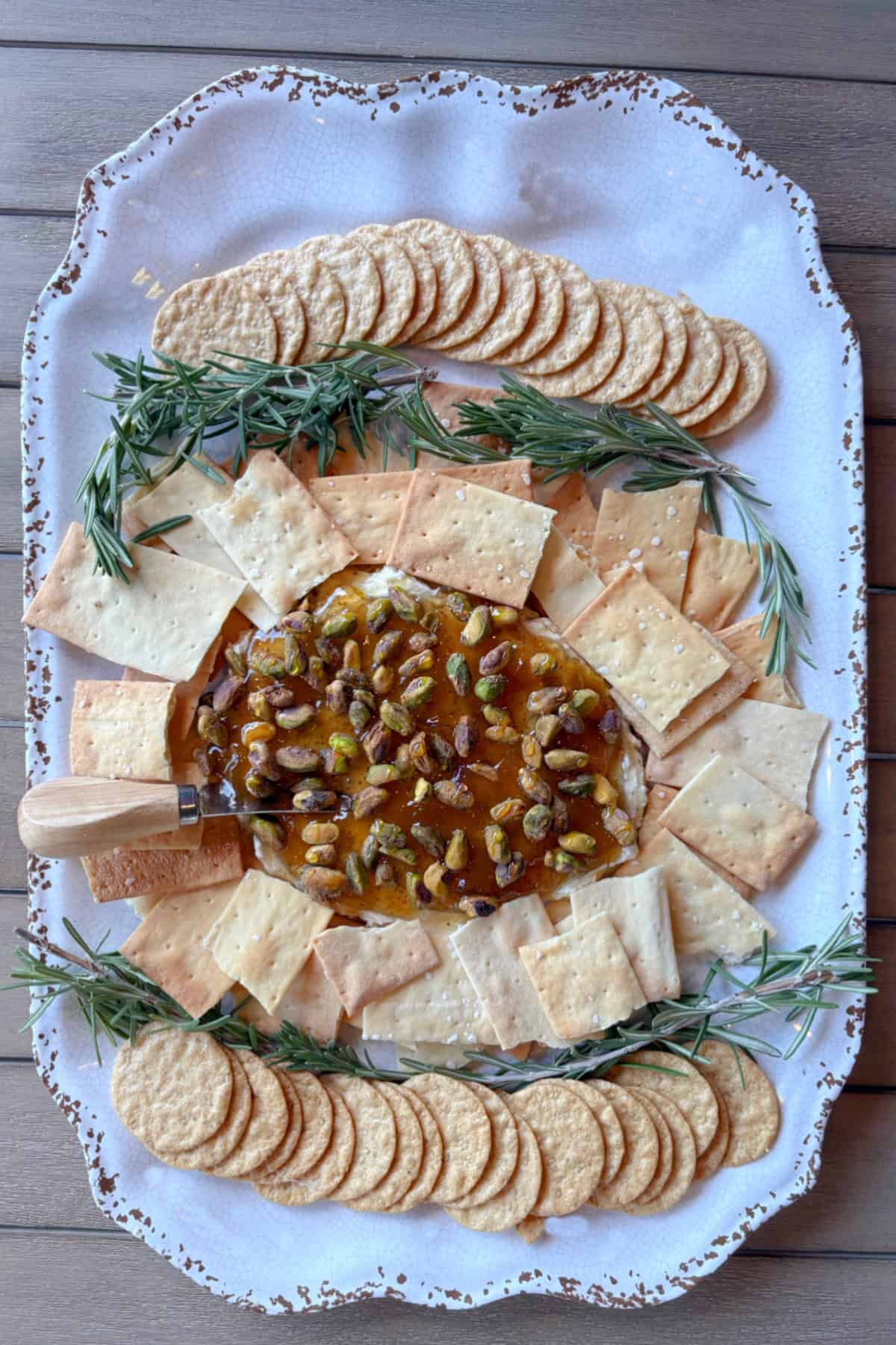 The easiest appetizer ever! Creamy Boursin topped with fig jam, pistachios, and hot honey. Sweet, salty, crunchy, and ready in minutes—perfect for parties! overhead shot of boursin cheese dip surrounded by crackers