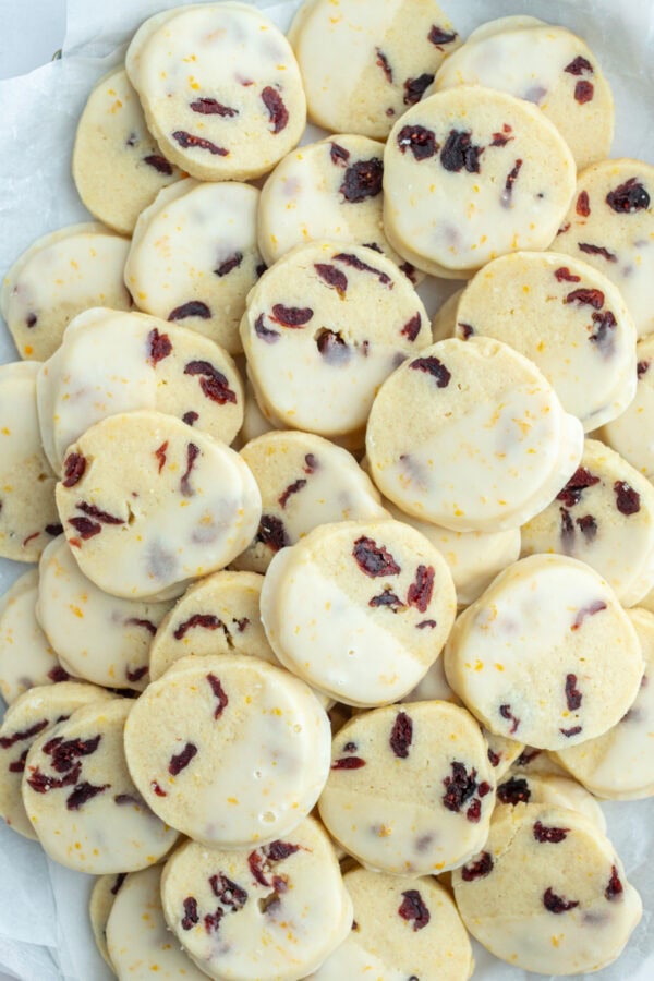 many cranberry orange cookies that have been dipped in glaze