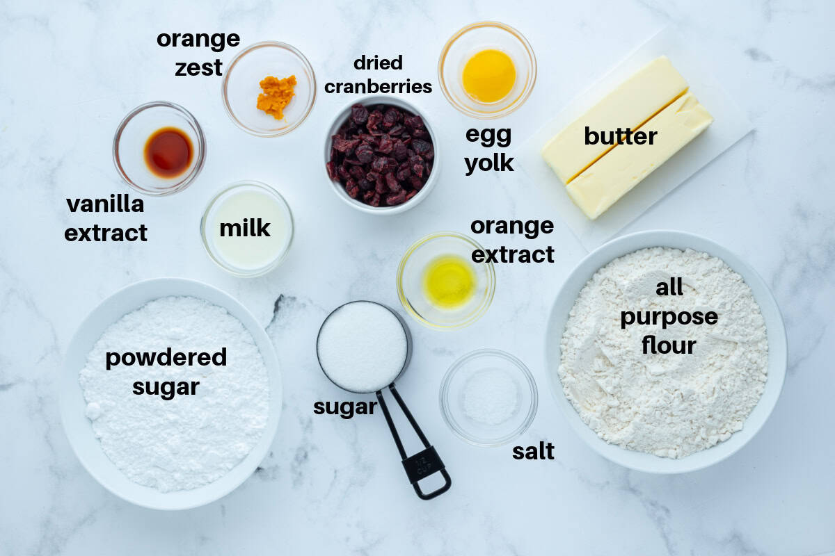 Bright, buttery Cranberry Orange Cookies loaded with dried cranberries and fresh orange zest, dipped in a sweet citrus glaze. A gorgeous slice-and-bake cookie for the holidays! ingredients displayed for making cranberry orange cookies