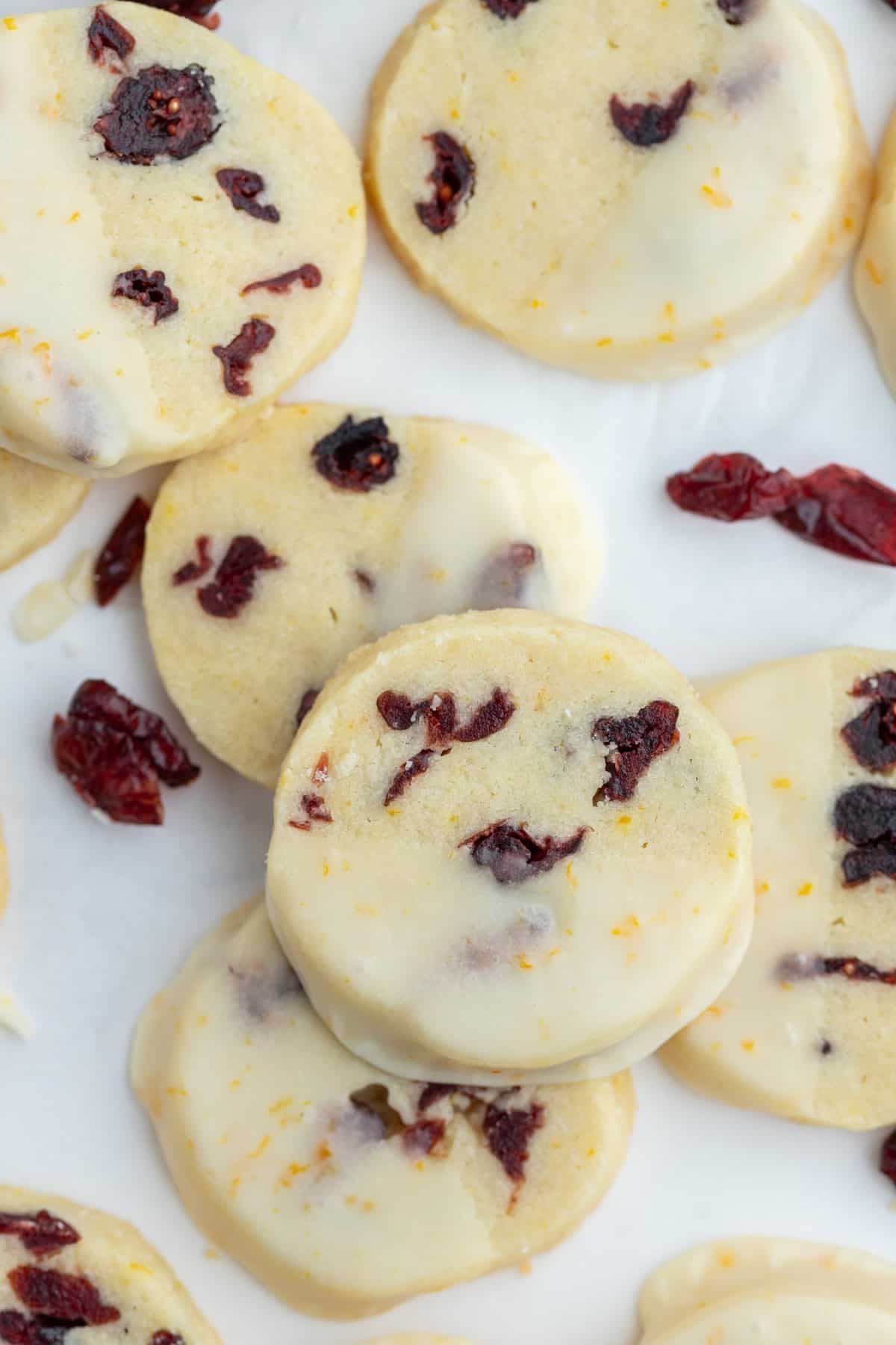 Bright, buttery Cranberry Orange Cookies loaded with dried cranberries and fresh orange zest, dipped in a sweet citrus glaze. A gorgeous slice-and-bake cookie for the holidays! cranberry orange cookies dipped in glaze