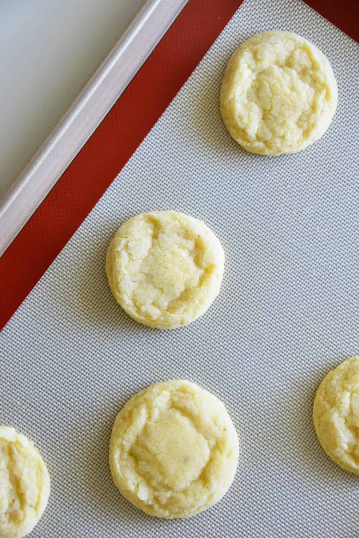 These soft and tender Eggnog Cookies taste just like classic holiday eggnog! Rolled in sugar and full of nutmeg flavor—perfect for Christmas cookie trays. baked eggnog cookies on a baking sheet