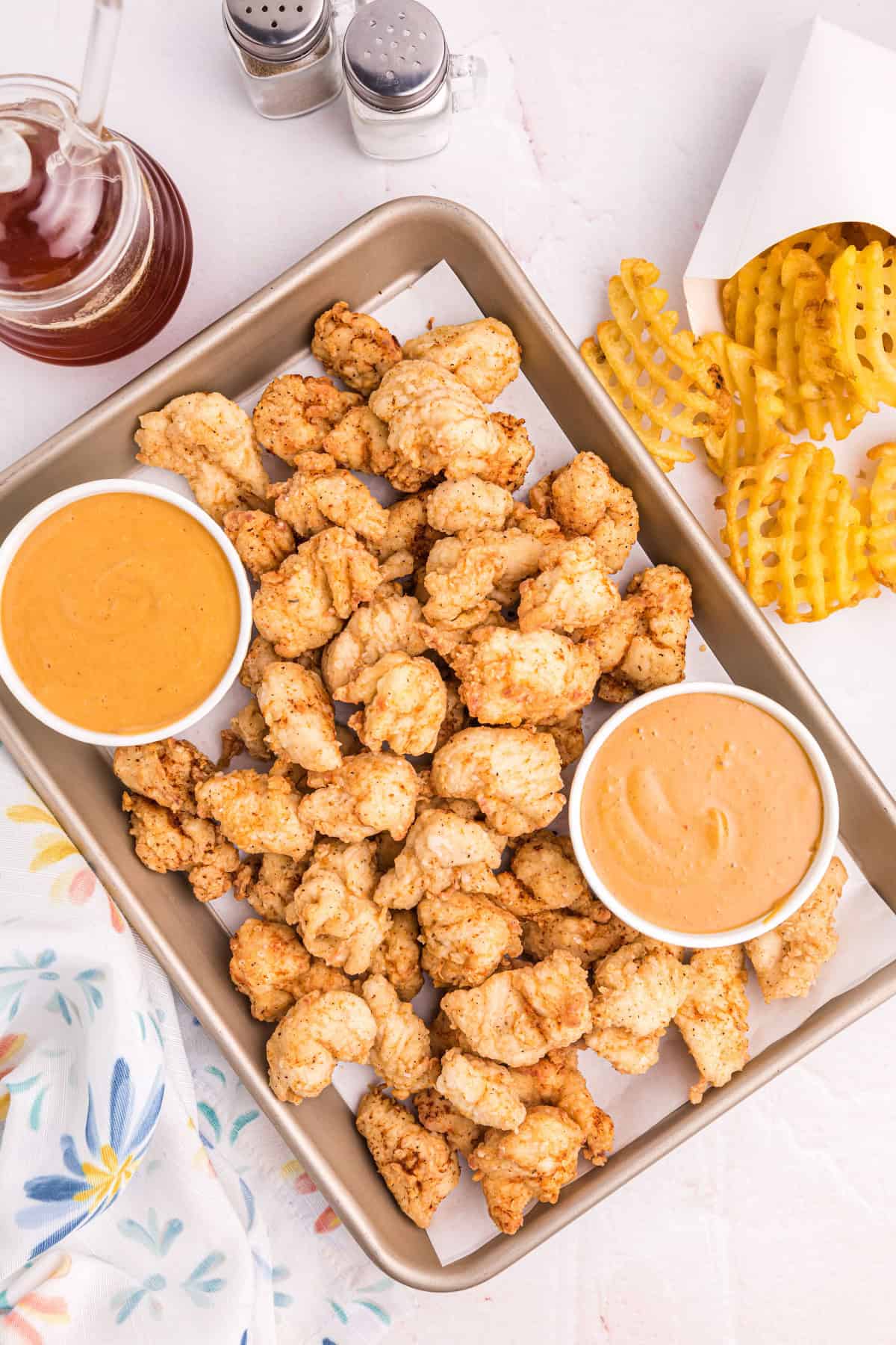 sheet pan of copycat chick-fil-a nuggets with bowls of sauce