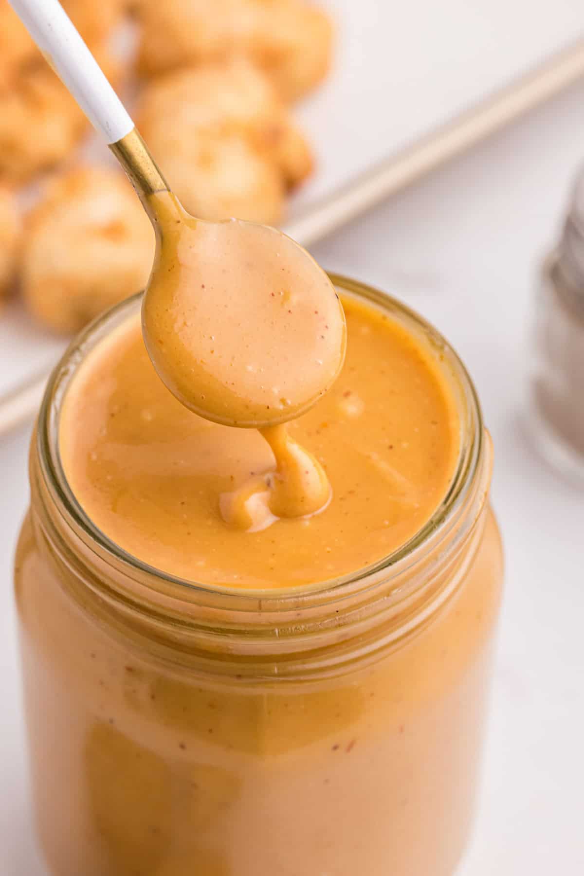 spooning into jar of copycat chick-fil-a sauce