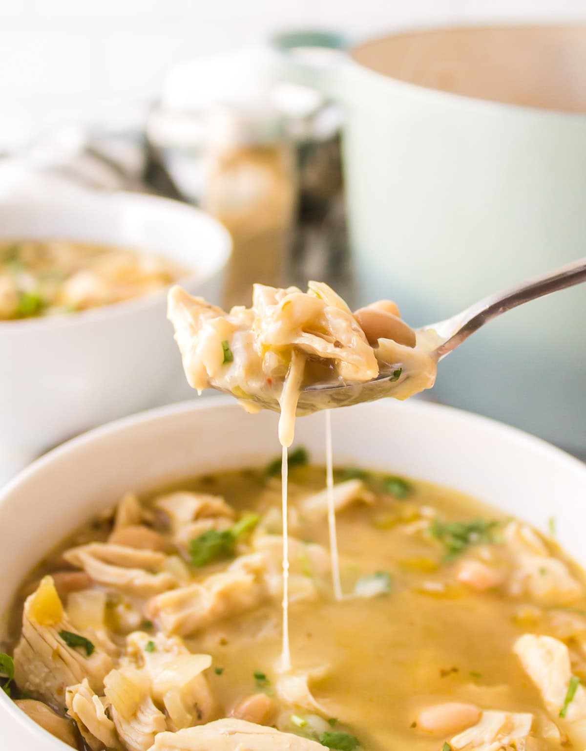 spoon full of white bean chicken chili over bowl