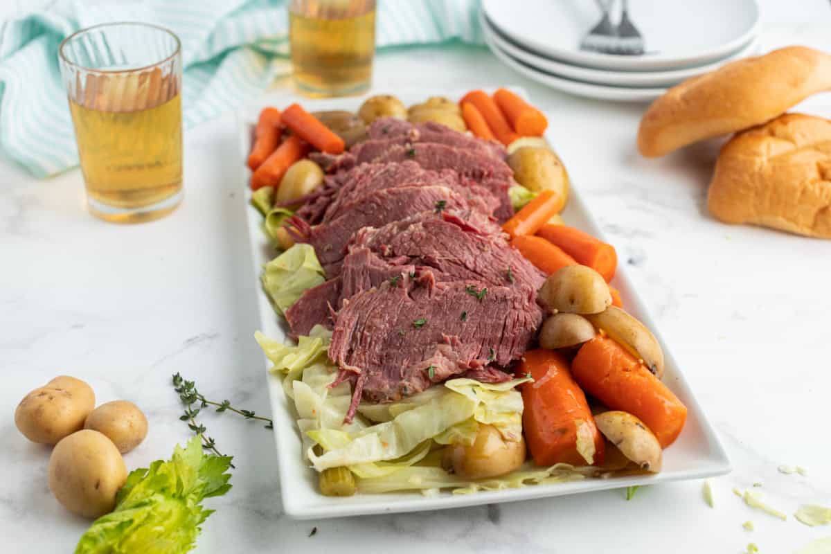 Slow Cooked Corned Beef and Cabbage is an easy, tender, and flavorful St. Patrick’s Day dinner made with brisket and hearty vegetables. sliced corned beef on a platter with veggies
