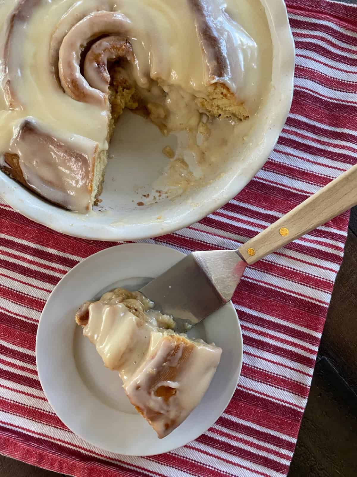 giant cinnamon roll with slice on a plate