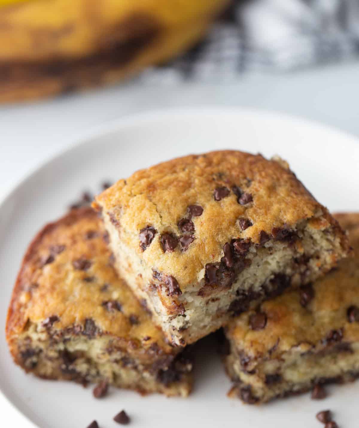 Chocolate chip banana snack cake that’s soft, moist and easy to make. A simple one-pan dessert everyone will love! pieces of chocolate chip banana snack cake on a plate