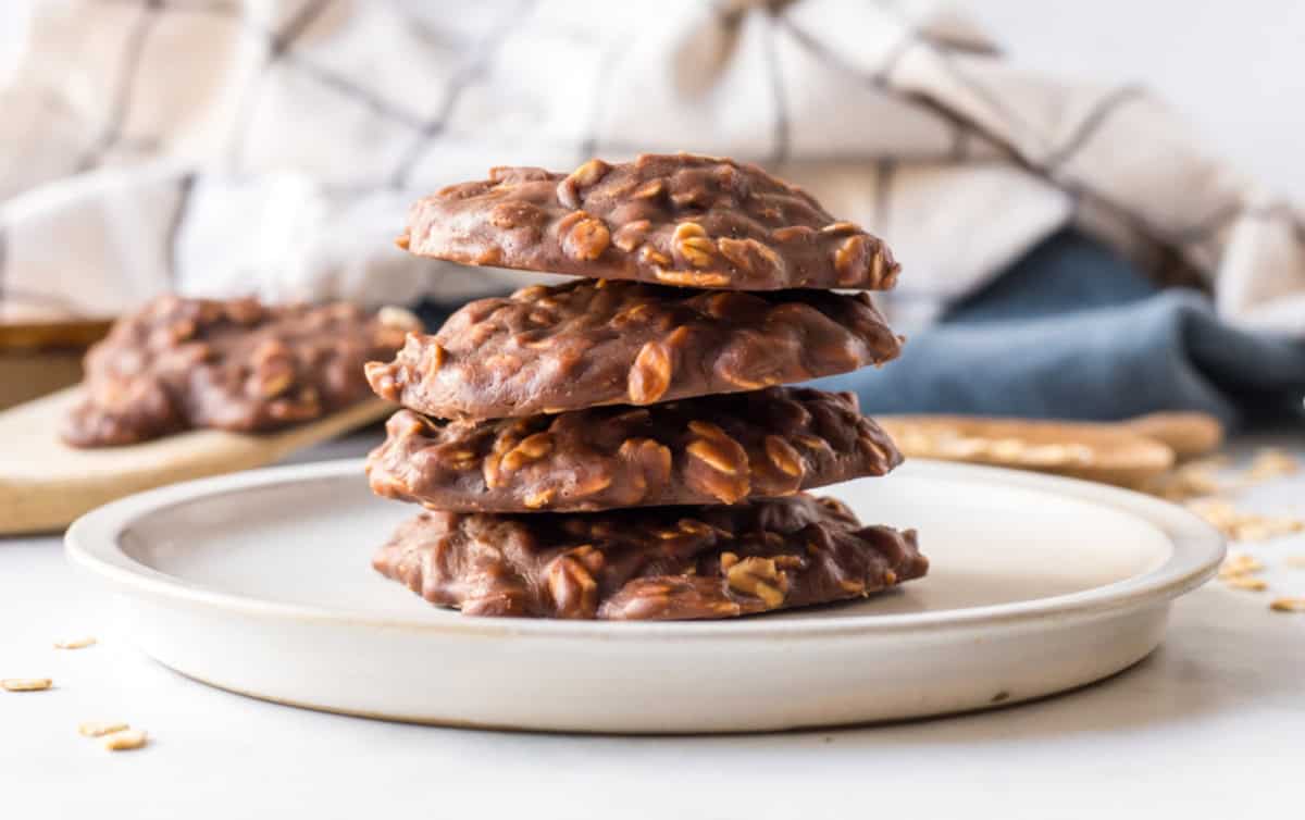 Chocolate peanut butter no bake cookies made with oats and cocoa. Easy, fudgy and perfect for a no-oven summer dessert! plate with stack of chocolate peanut butter no bake cookies
