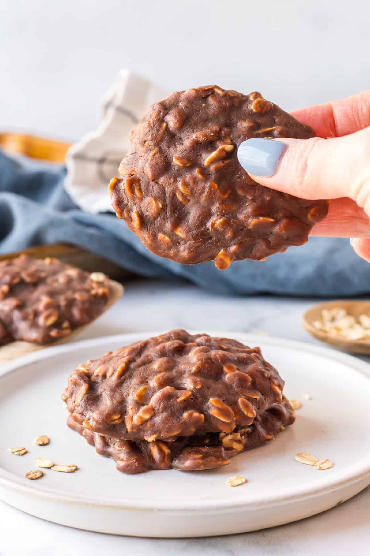 Chocolate peanut butter no bake cookies made with oats and cocoa. Easy, fudgy and perfect for a no-oven summer dessert! hand holding chocolate peanut butter no bake cookie
