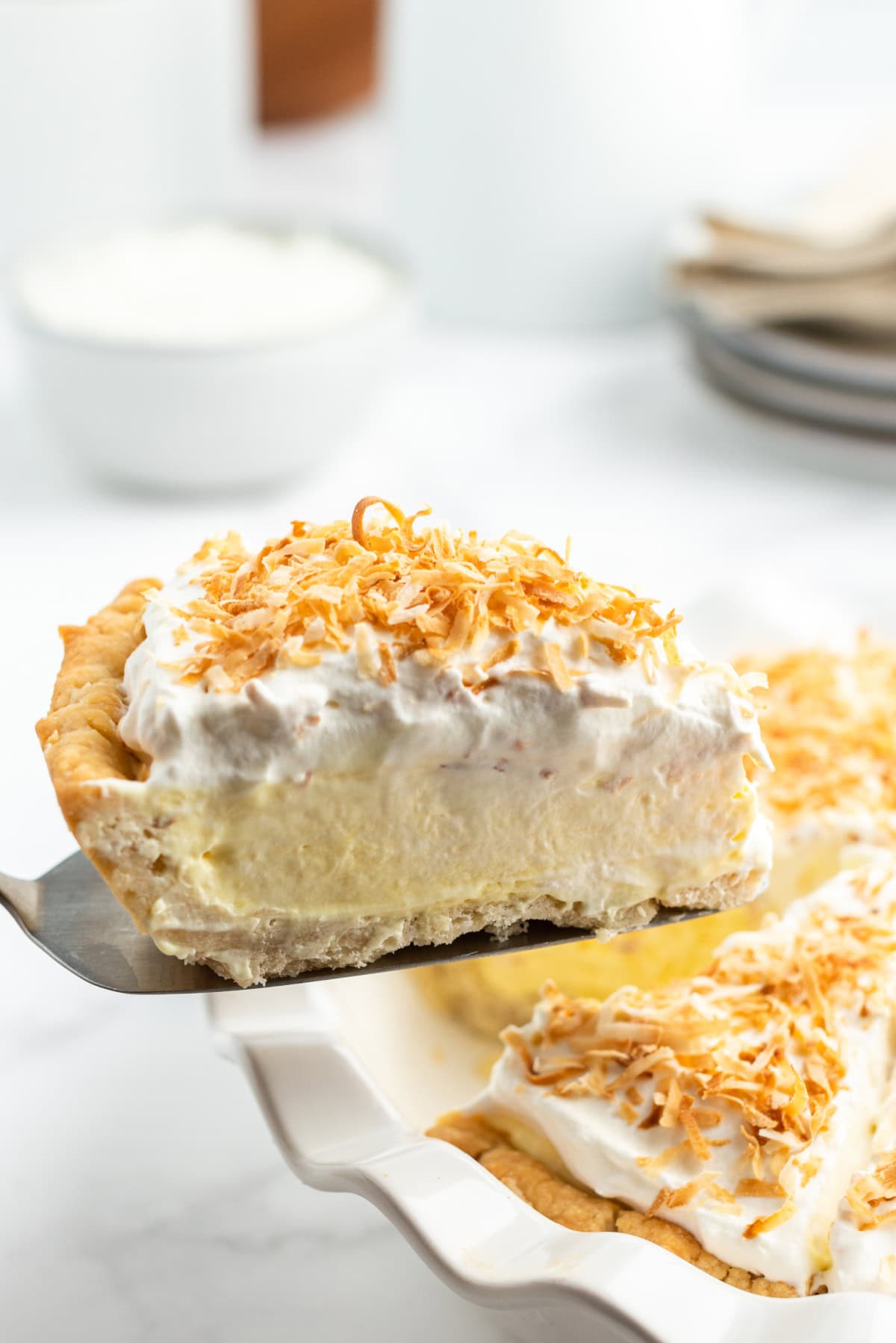 spatula holding up slice of coconut cream pie