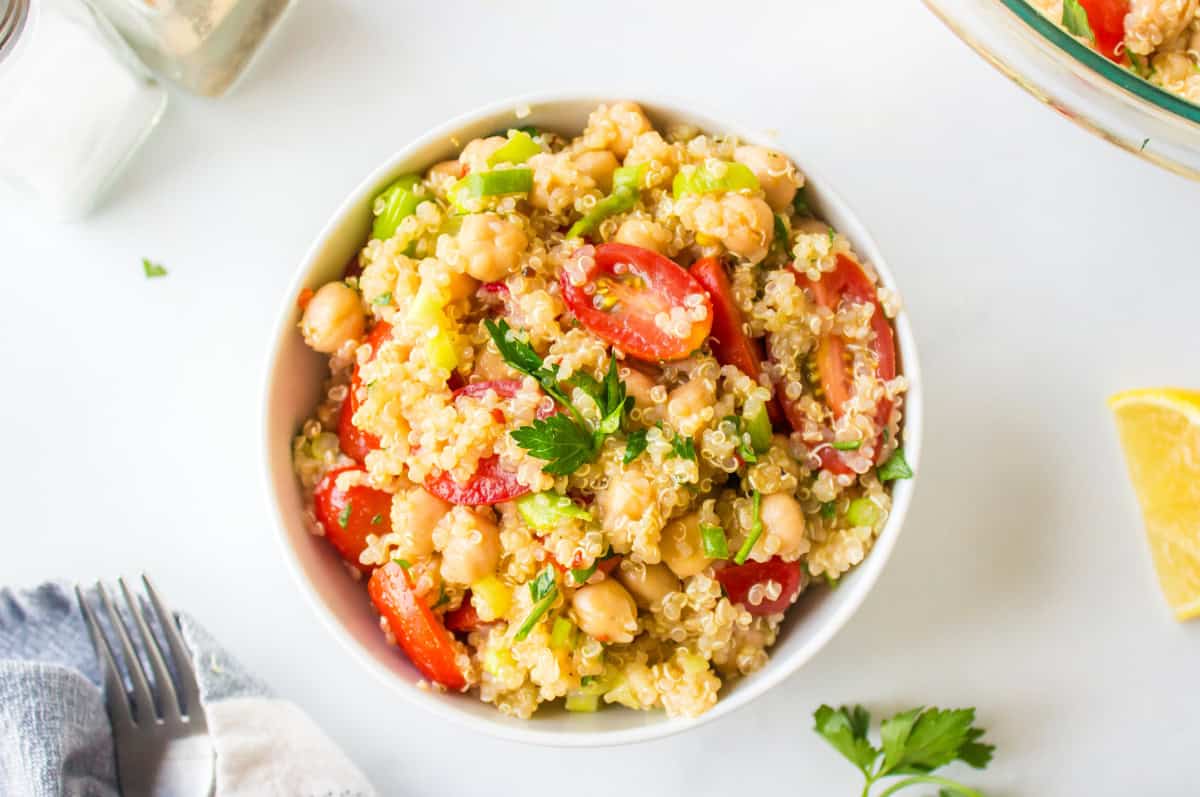Easy quinoa salad with chickpeas, tomatoes and a lemon dressing. Fresh, healthy and perfect for meal prep or a quick meal! overhead shot of easy quinoa salad in bowl