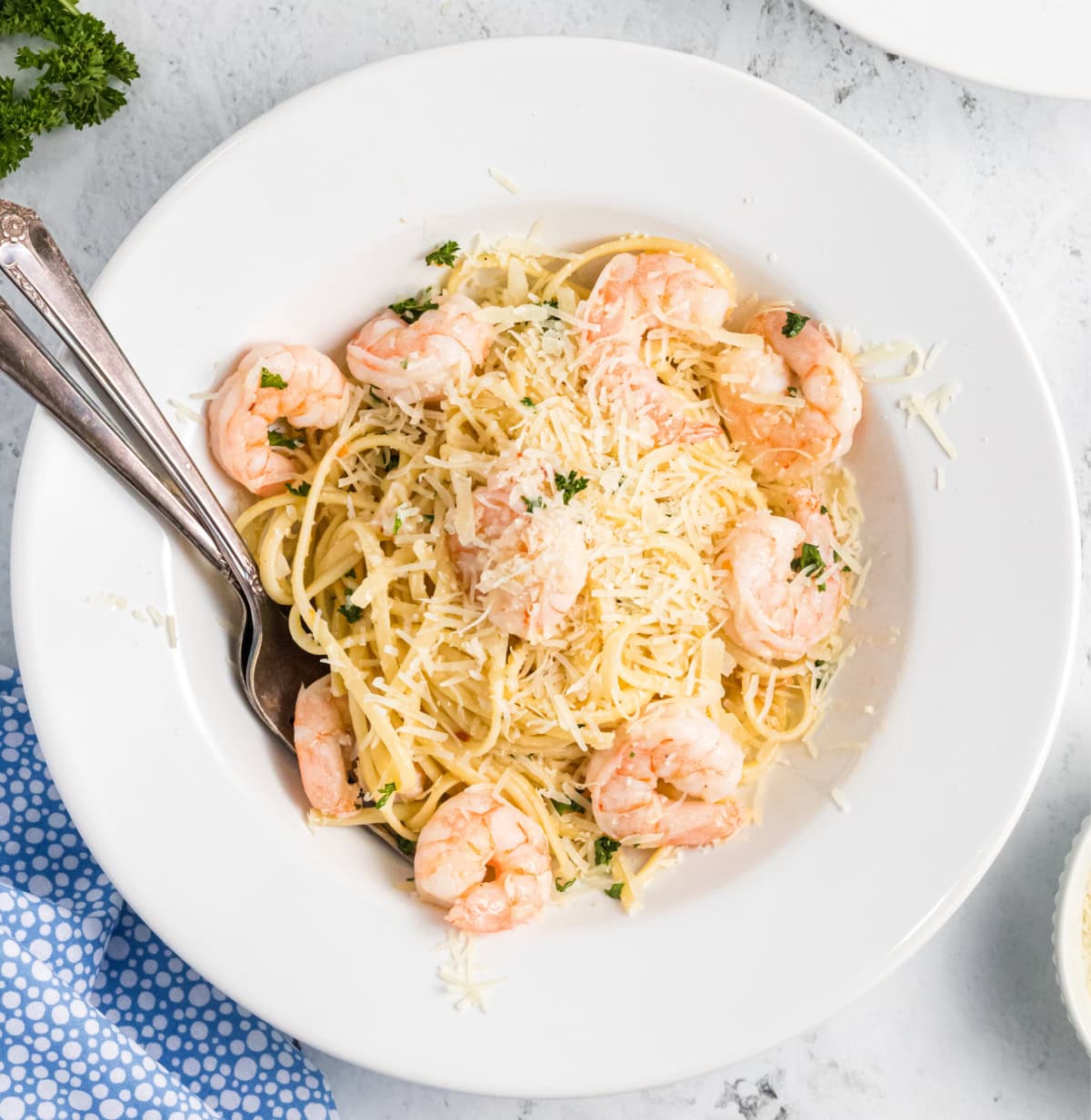 Shrimp Scampi Linguine is a quick and easy dinner with garlic, butter and lemon. A simple shrimp pasta recipe everyone loves. shrimp scampi linguine in bowl with Parmesan