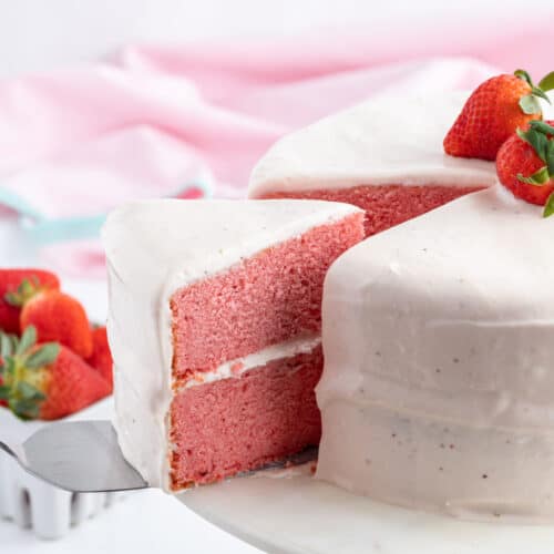 strawberry layer cake with slice taken out of it
