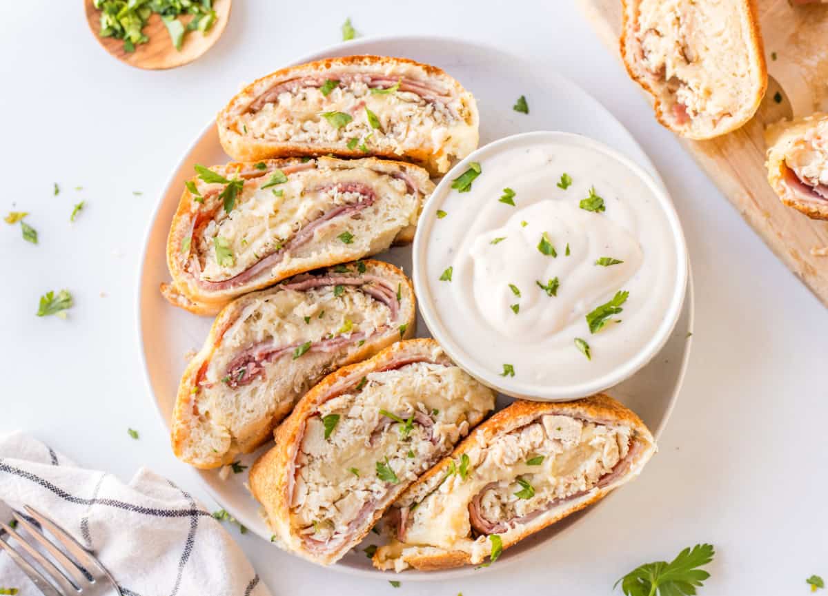 slices of chicken cordon bleu stromboli on a plate with sauce