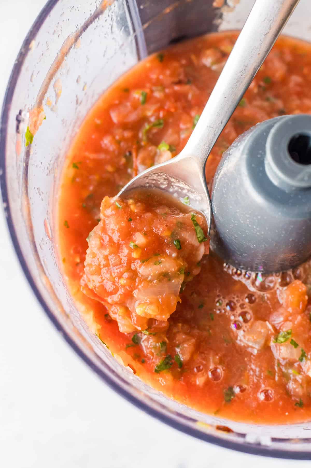 spoon in food processor of salsa